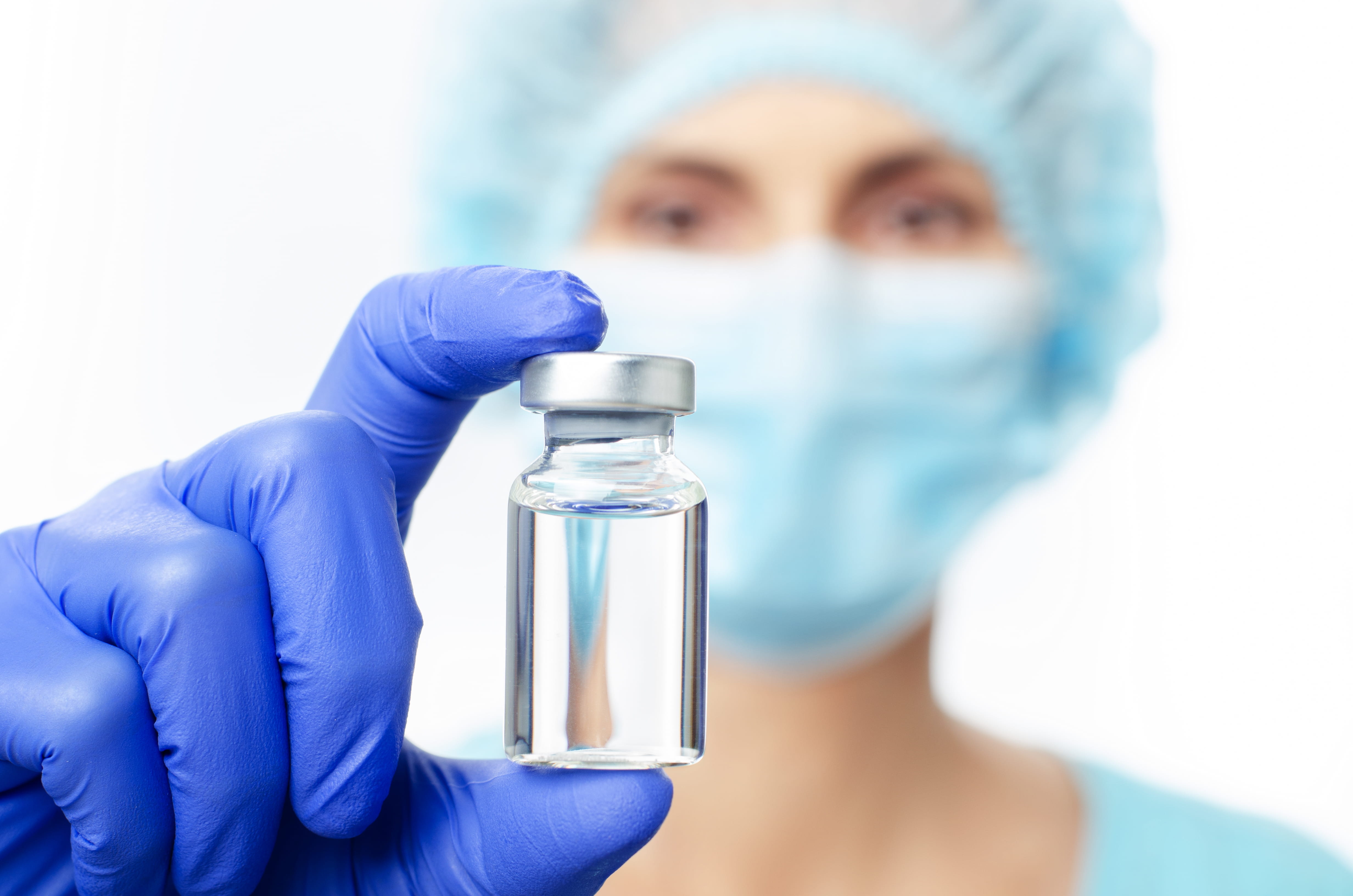 Gloved technician holding a clear vial to illustrate low endotoxin control in pharmaceutical manufacturing.
