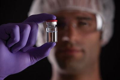 A doctor holding up a vial