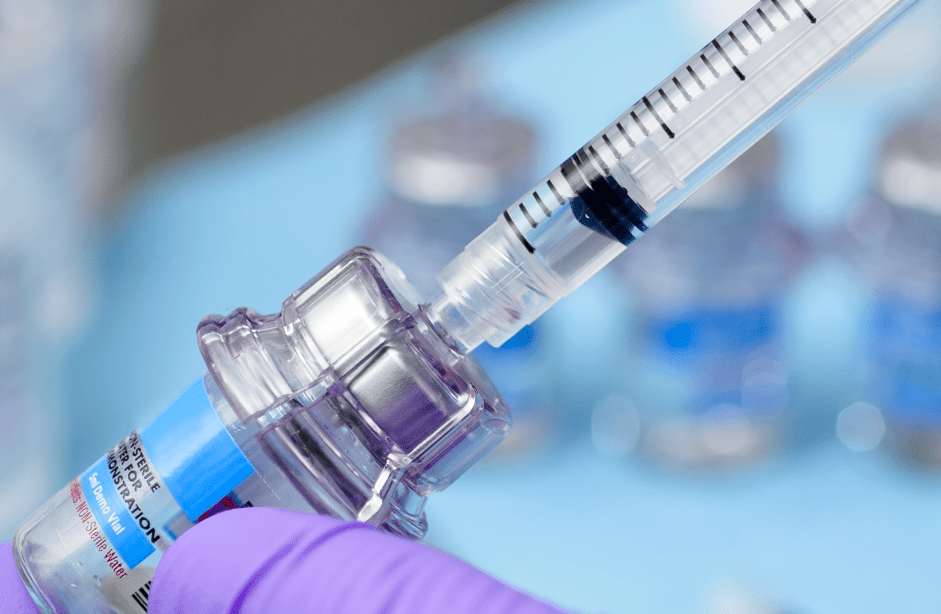 Close-up of vial adapter with syringe for drug preparation